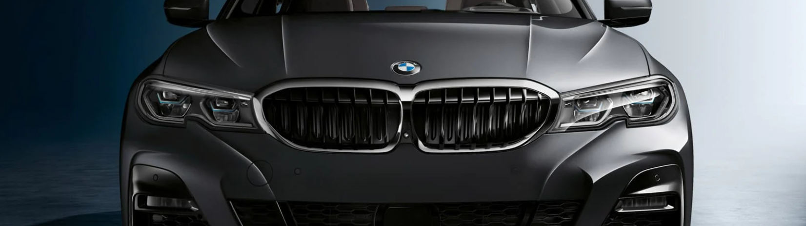 black BMW 3 series parked with a dark background