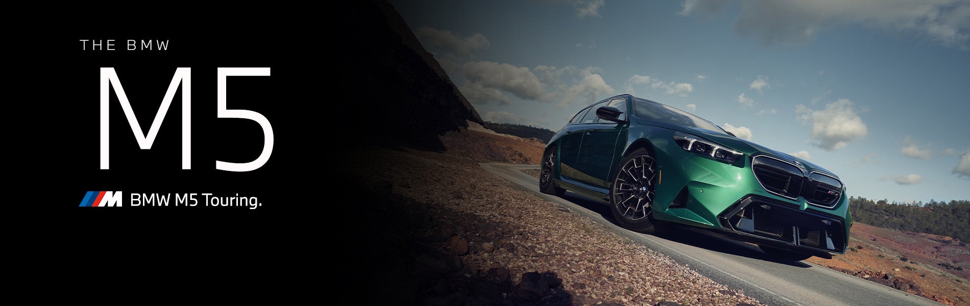 The new BMW M5 Touring in green driving down desert road | BMW of Grand Blanc in Grand Blanc MI